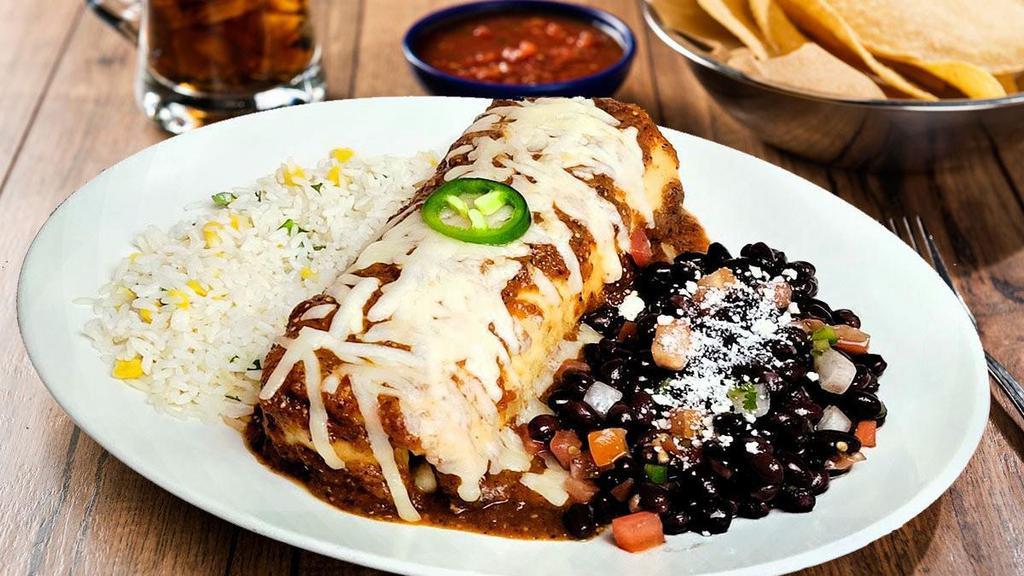 Veggie Chimichanga · Our Veggie Burrito fried crispy and smothered with roasted red chile tomatillo salsa. Served with cilantro lime rice and black beans or sautéed vegetables.
