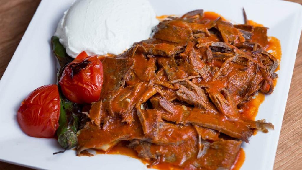 Iskender Kebab · Lamb gyro kebab in a lightly hot tomato sauce over toasted pita bread. Served with yogurt