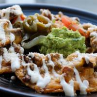 Nachos · Tortillas chip topped with beans, cheese, lettuce, tomato, onions, jalapeño, sour cream and ...