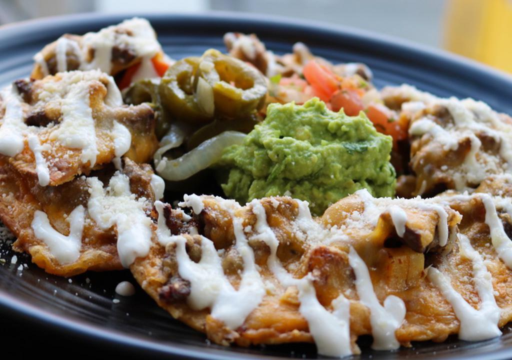 Nachos · Tortillas chip topped with beans, cheese, lettuce, tomato, onions, jalapeño, sour cream and guacamole.