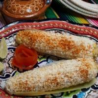 Elote · Two street style Mexican corn on the. cob, topped with mayo, queso cotija,. tajin & limes on...