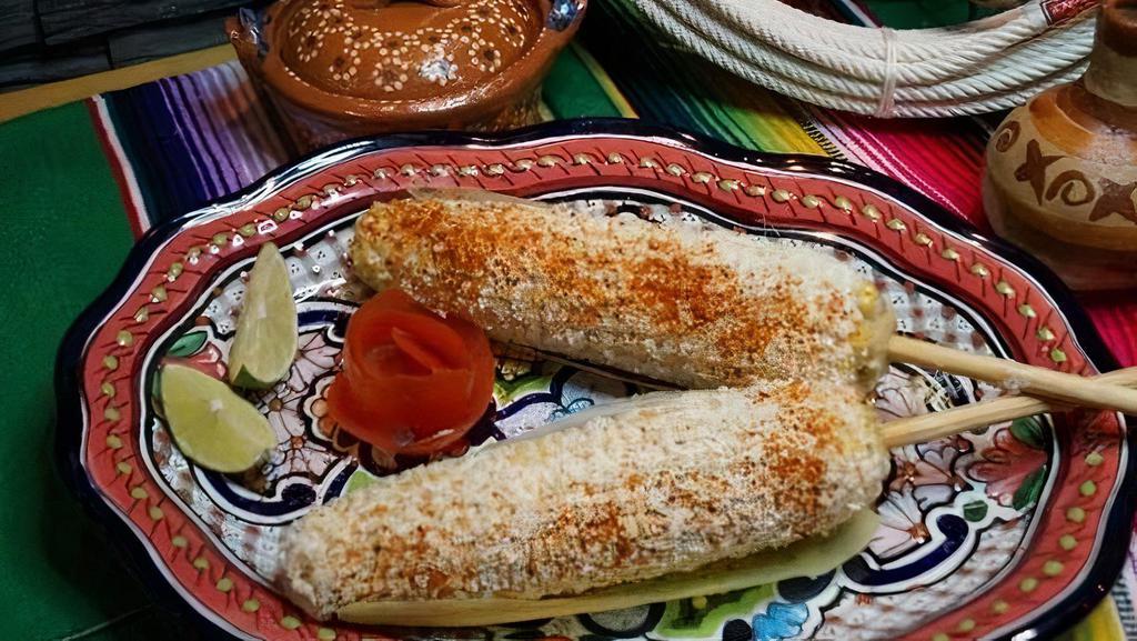 Elote · Two street style Mexican corn on the. cob, topped with mayo, queso cotija,. tajin & limes on the side.