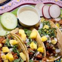 Pastor Tacos · Our sweet savory marinated grilled. pork, topped with pineapple, cilantro, &. white onions, ...
