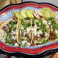 Carnitas Tacos · Traditional pork carnitas topped with. cilantro & white onion with a side of. limes, garnish...