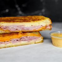 Smoked Ham & Three Monte Cristo · Smoked ham, Cheddar, Swiss, and Parmesan cheeses melted between egg dipped, griddled sourdou...