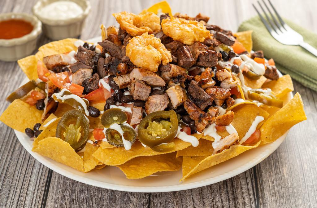 Shrimp Nachos · Homemade yellow corn tortilla chips covered with melted cheese, black beans, jalapeños, tomatoes, and sour cream.