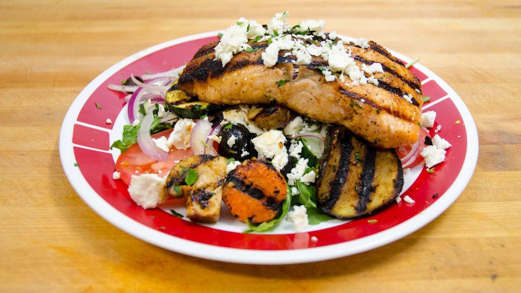 Large Grilled Salmon Salad · Grilled salmon over arugula salad with grilled vegetables: zucchini, carrots, mushrooms, eggplant, feta cheese, and lemon and oil dressing.