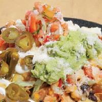 Nachos Supremos · Tortilla chips smothered with melted cheese, black beans, lettuce and tomato. Topped with gu...