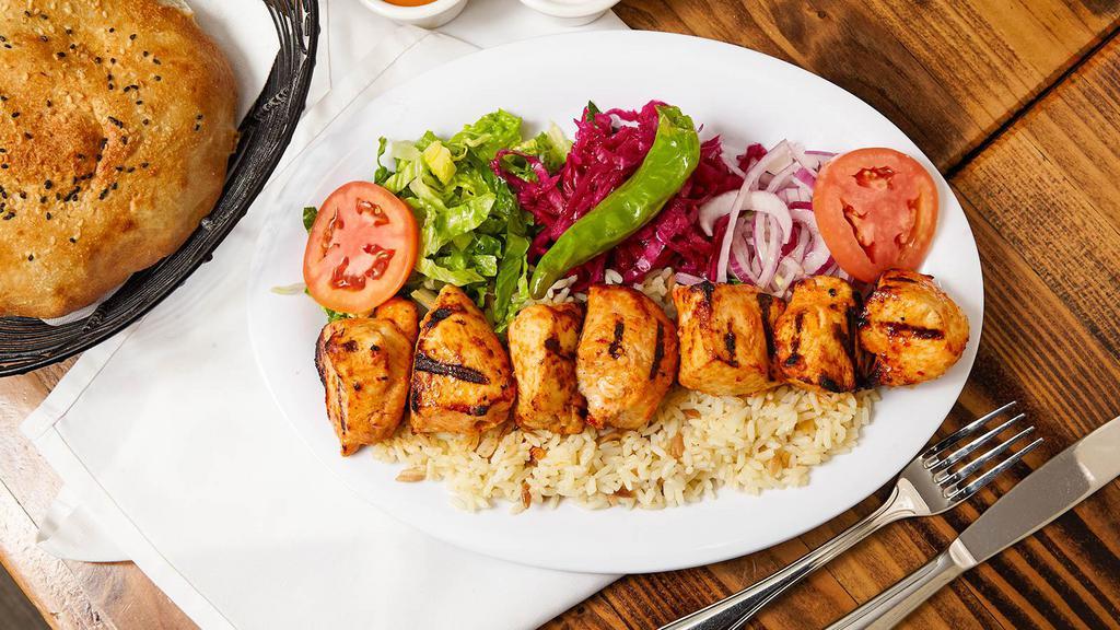 Chicken Shish Plate · Char-grilled cubes of chicken breast with Turkish seasoning. Served with bulgur (cracked wheat) or white rice, lettuce, red cabbage, onion, fresh tomatoes, homemade bread and hot and white sauce on the side. No substitutions.