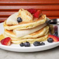 Ricotta Pancakes · Honeycomb butter, banana, strawberries, and blueberries served with 100% pure maple syrup