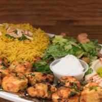 Shish Tawook · 2 skewers of marinated chicken served with rice or fries, home salad, hummus and bread.