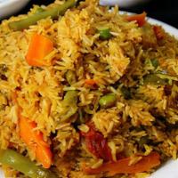 Vegetables Biryani · Rice served with a mix of vegetables, spices, home salad, hummus, soup, and bread.