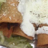 Tacos Dorados · 3 fried rolled corn tortilla stuffed with potatoes and sausage topped with lettuce, onions a...