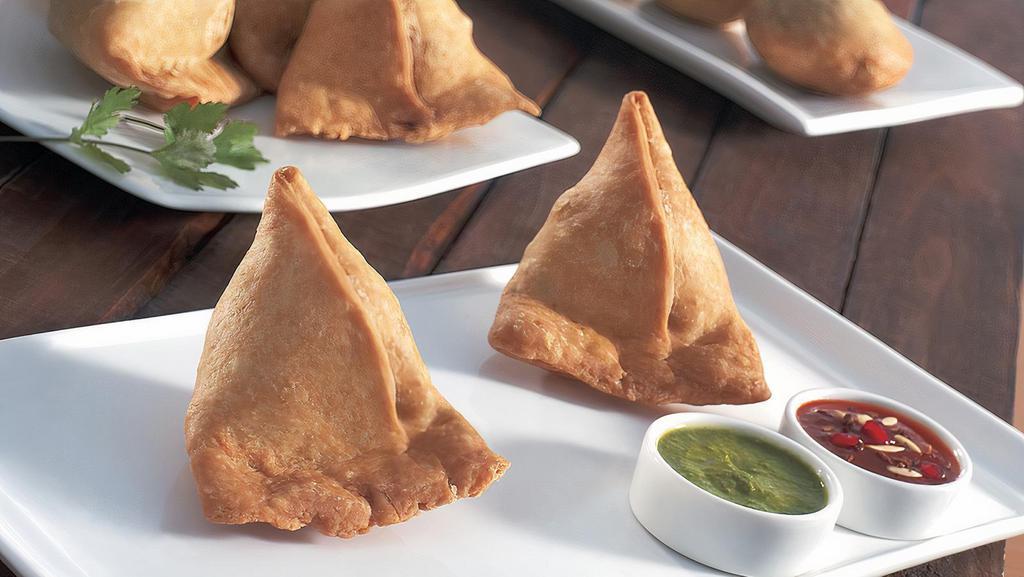 Samosa Plate (2 Pcs.) · A famous Indian snacks, fried or baked with a savoury filling such as spiced potatoes, onions peas, lentils.