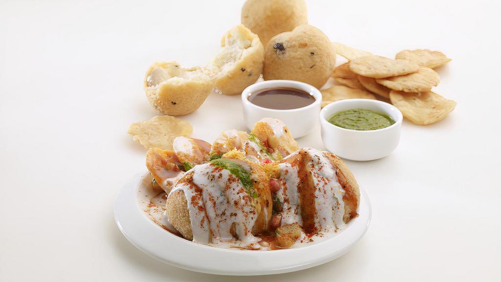 Bhalla Papri · Deep fried lentil fluffy balls, garnished with dahi (curd), papdi, honey chilly paste (chutney) and spices.