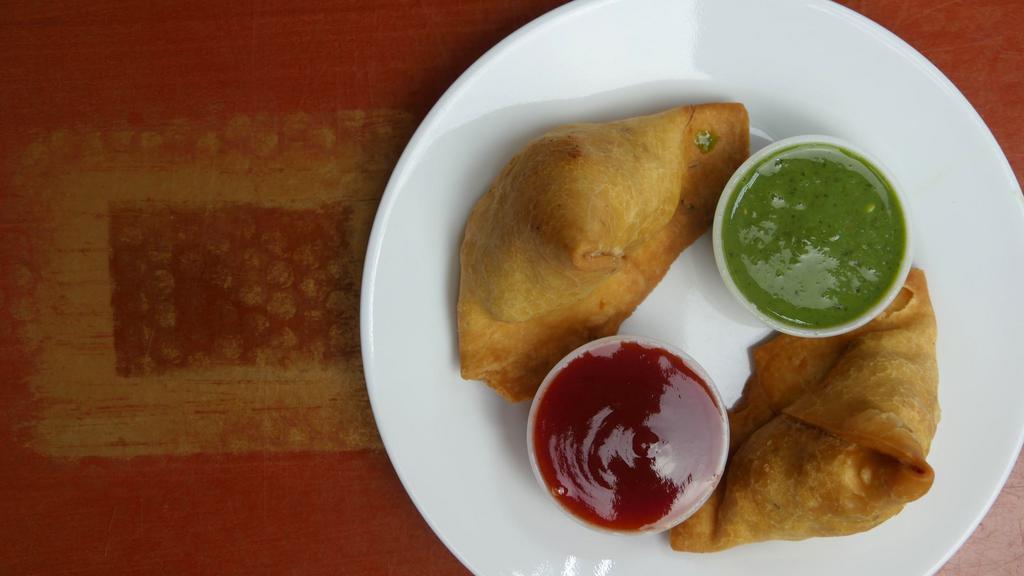 Samosa Veg (2 Pieces) · Crispy fried turnover, deliciously filled with medium hot spices potatoes & green peas.