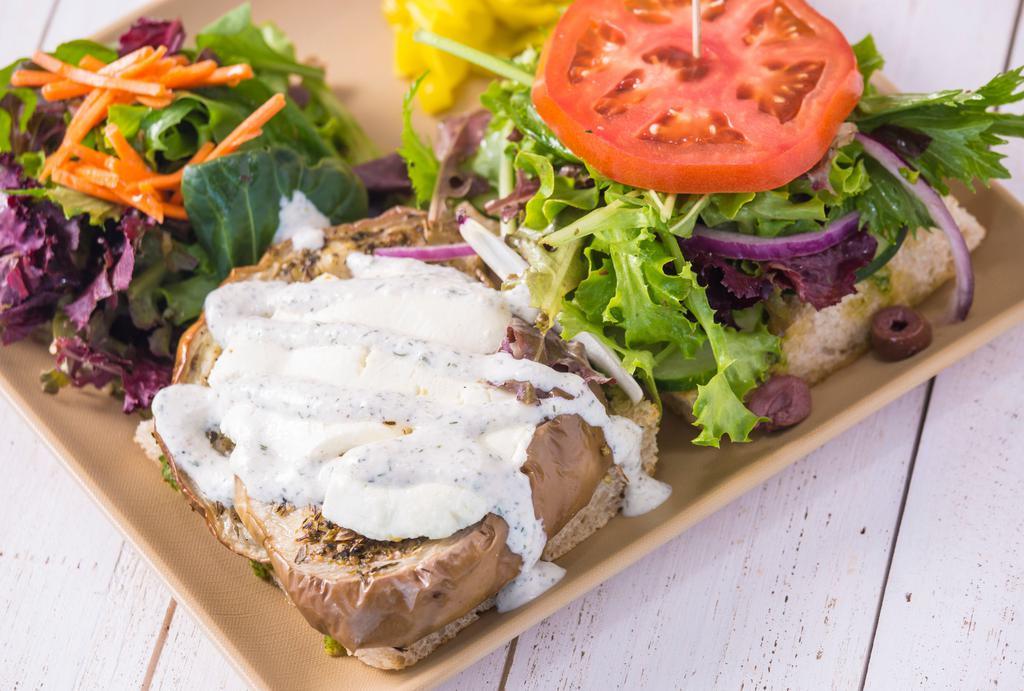 Eggplant & Goat Cheese Sandwich · Focaccia, mac nut pesto, roasted eggplant, goat cheese, spring mix, lemon-herb dressing, cucumber, olives, onion, tzatziki, and tomato. Served with a side house salad