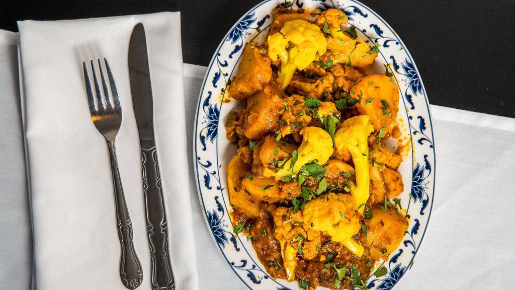 Aloo Gobi · Florets of cauliflower stir fried with masala and potatoes, then cooked with tomato and onion.