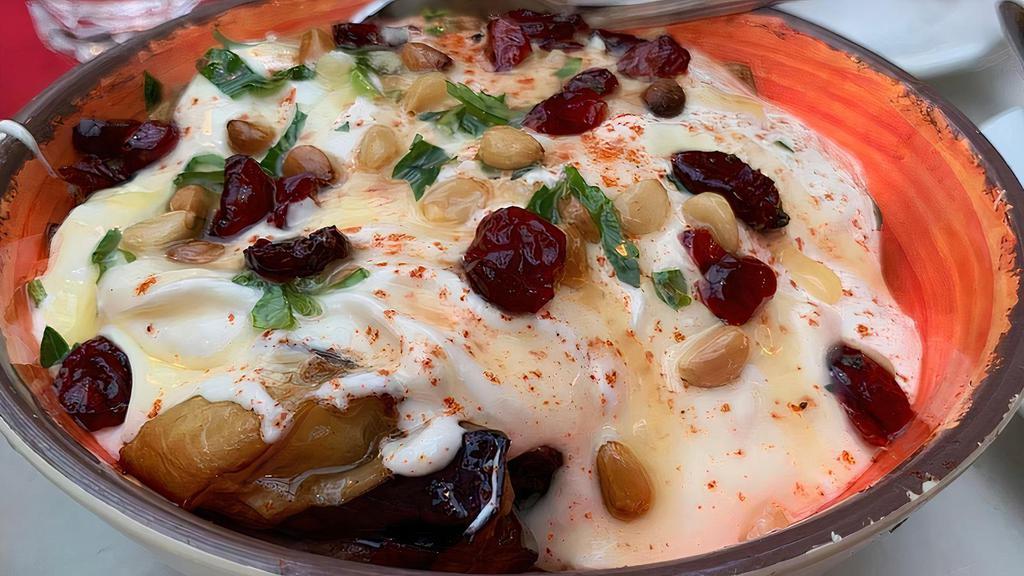  - Fattet Al-Betenjane · Eggplant topped with toasted pita bread. Smothered with garlic yogurt sauce and sauteed pine nuts.