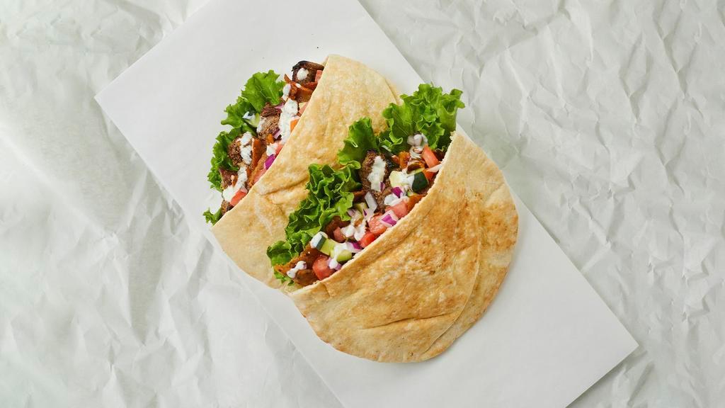 Beef And Lamb Shawarma Pita · Mixed beef & lamb shawarma with lettuce, tomatoes, cucumber, onions, and your choice of sauce wrapped in a pita