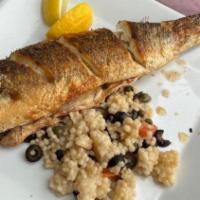 Mediterranean Branzino · Whole fish, herb breadcrumbs, pecorino, olives, capers charred tomato over couscous with cit...