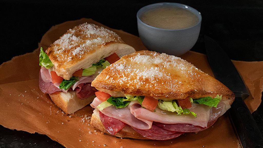 Italian Deli Boat · Calzone style sandwich baked with pizza dough stuffed with ham, salami, provolone, lettuce & tomatoes. Served with a side of Italian dressing. (10