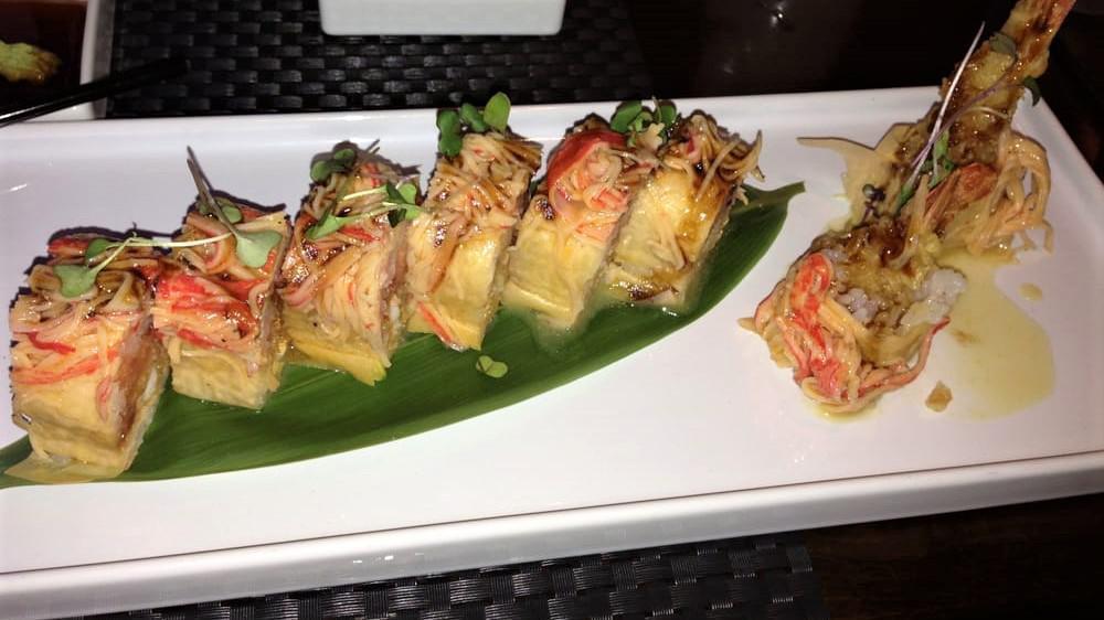 Dragon Roll · Eel and cucumber wrapped inside, topped with slices avocado, caviar and eel sauce on it.