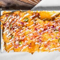 Loaded Nachos · Layered tortilla chips topped with cheese sauce, shredded lettuce, pico de gallo and slice j...