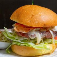 Smokehouse Burger · Lettuce, tomato, BBQ sauce, cheddar cheese, onion rings, bacon.