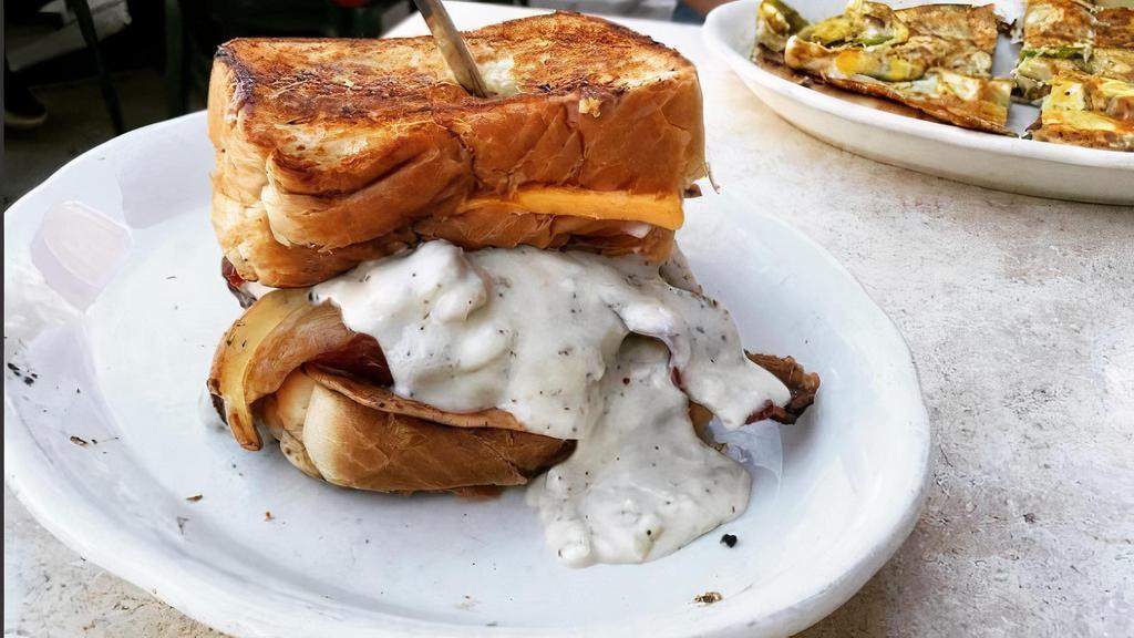 Country Mofo · Chicken patty, Ham, Fried egg & Sausage Gravy on two Texas Toast Grilled Cheese Sandwiches.