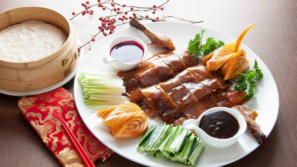 Peking Duck (Half) · A Chinese delicacy. Roasted duck characterized by its thin, crispy skin and tender meat, provided with cucumbers, scallions, hoisin sauce, rose petal garlic sauce and ten pieces steamed pancakes. Served as a precursor to the main course.