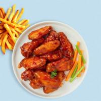 Brawny Buffalo Wings · Fresh chicken wings breaded, fried until golden brown, and tossed in buffalo sauce. Served w...