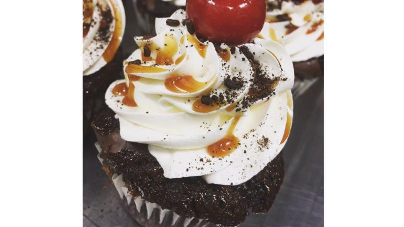 Brownie Sundae Cupcake · Decadent dark chocolate, milk chocolate, and fudge brownies topped with our signature buttercream, chocolate syrup, rainbow sprinkles, and a cherry on top! For true brownie lovers!