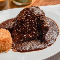 Mole Poblano · Tradicional mole sauce with a concoction of chocolate, dry chiles, plantains, nuts, raisins ...