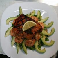 Salmon Spinach Salad · Marinated grilled salmon served alongside tomatoes and black olives on a bed of mixed greens...