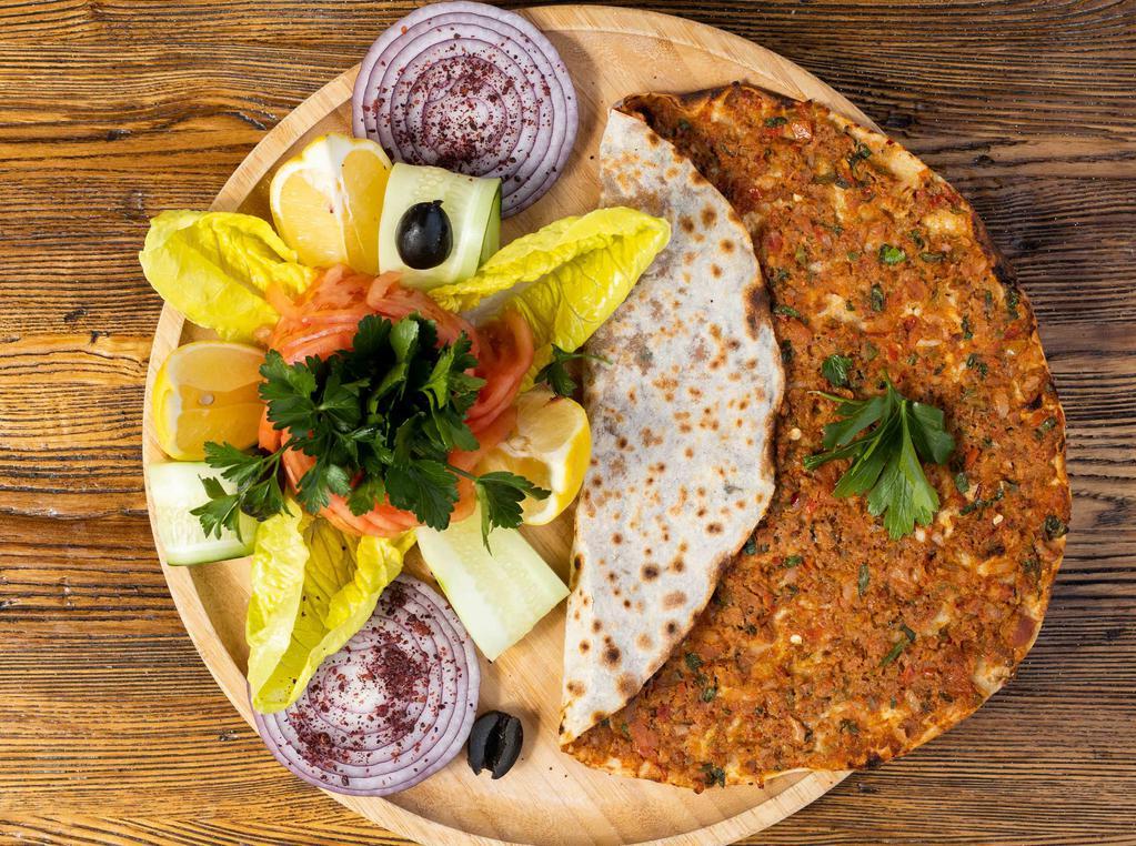 Lahmacun · Meat pie. Anatolia's version of ancient Turkish meat pie with ground lamb, topped with parsley, fresh tomatoes, red peppers and onion all on thin dough.