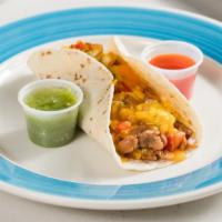 Migas · Scrambled eggs, tortilla chips, pico de gallo, cheese and refried beans in a flour tortilla.