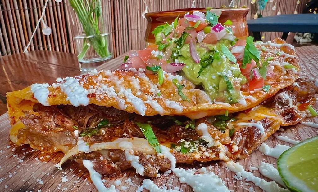 Birria Quesadilla · Short Rib Meat Cooked In Birria Sauce, Oaxaca Cheese, Topped With Sour Cream, Homemade Guacamole, Pico De Gallo, Cotija Cheese, Served With Consome