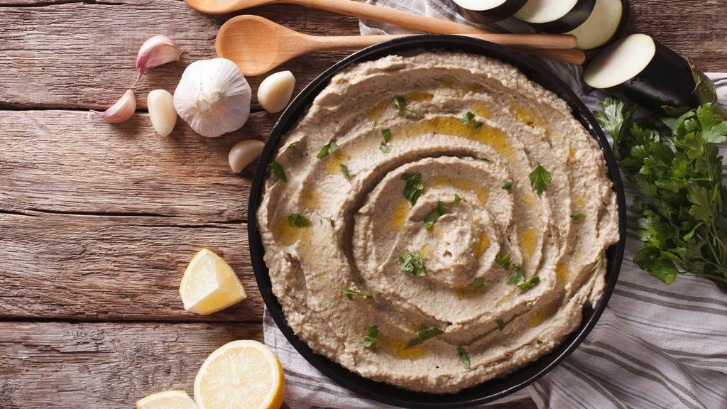 Baba Ghanouj  · Delicious flame roasted, eggplant based dip made with tahini, yogurt, garlic, lemon juice, and olive oil, served with pita chips.