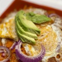 Chilaquiles De Pollo · Chilaquiles with shredded chicken then topped with sour cream, cotija cheese, onions, and av...