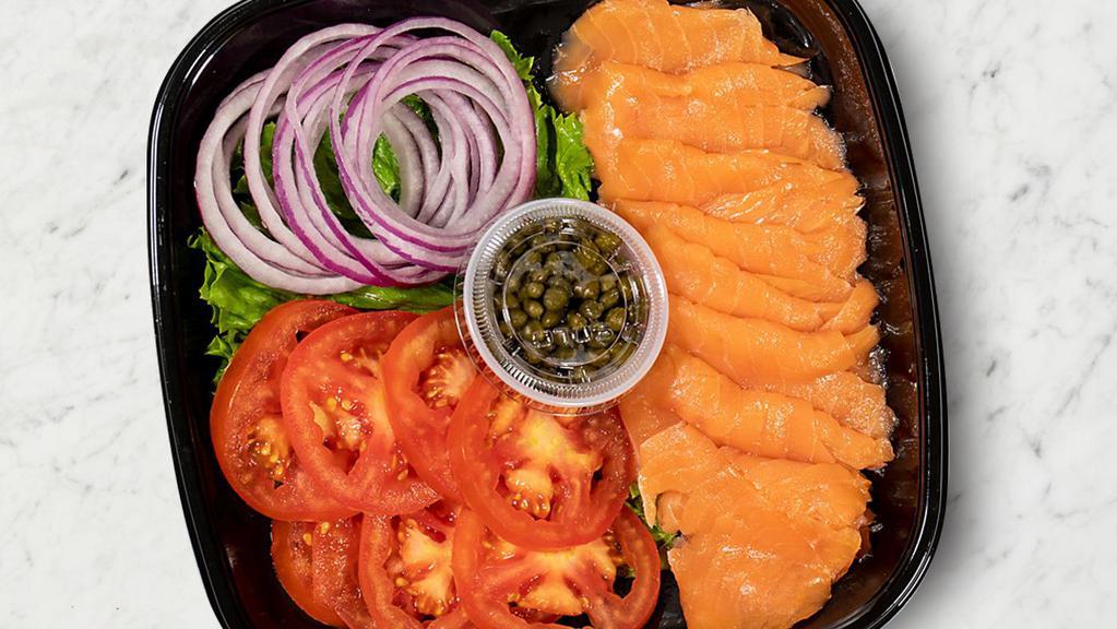 Smoked Salmon Plate · 8 pieces of smoked salmon, 8 slices of tomato, 16 red onion rings, 1 oz of capers, along with leaf lettuce.  Perfect add on to your Bagel Bundle!