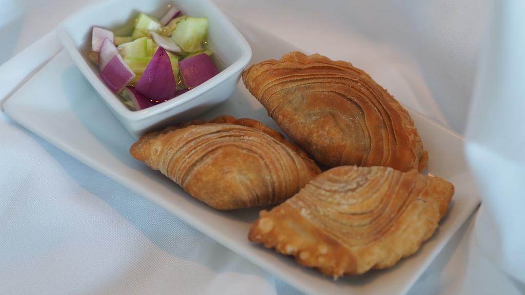 Curry Puffs* · Fried curry puff stuffed with potato, onion, carrot, curry powder, and served with cucumber sauce (3 pieces)