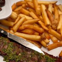 Skirt Steak · Grilled skirt steak with chimichurri sauce and seasoned french fries.