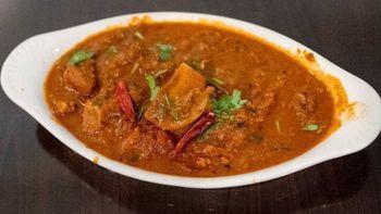 Hyderabad Goat Curry · Marinated and cooked with special spices, onions, tomatoes and herbs in Hyderabad style.