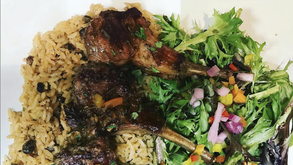 Rosemary Lamb Chop Lollipops · Served with yellow rice and a freshly tossed green salad
