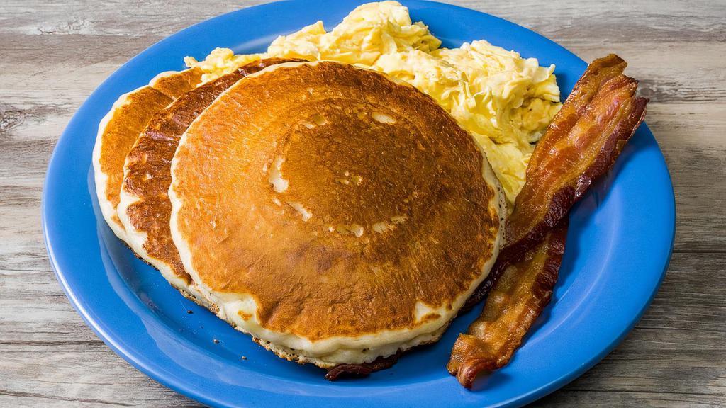 Cakes, Eggs And Bacon Pancake · Two of the best pancakes in town, two farm-fresh eggs any style, and two strips of applewood-smoked bacon. Served with butter and syrup.