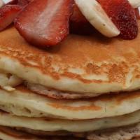 Strawberry Banana Pancakes · Four buttermilk pancakes topped with fresh strawberries, sliced banana, and whipped topping....