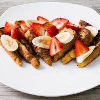 Strawberry Banana French Toast · Four slices of French toast dusted with powdered sugar and topped with fresh strawberries, b...