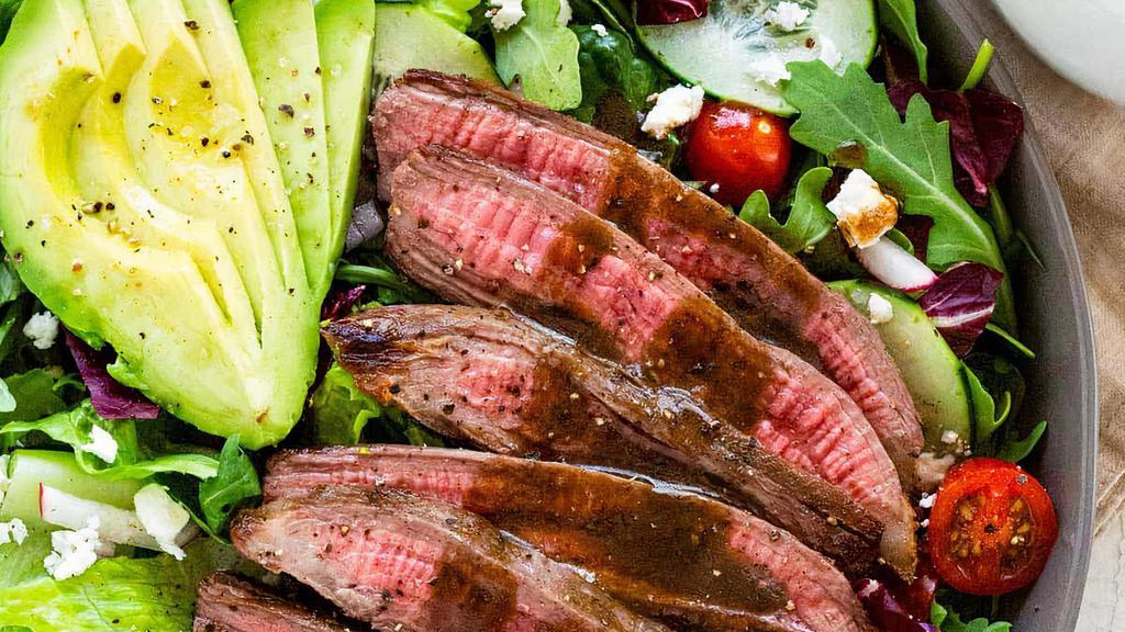 Bistro Skirt Steak Salad · Tender pieces of thinly sliced Skirt Steak over mixed mesclun greens, avocado, cherry tomatoes, sliced cucumber, red onions, Julienne peppers, red cabbage carrots & Goat Cheese.