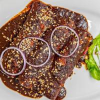 Enchiladas With Mole Sauce · Three roll up tortillas filled with chicken, covered with mole sauce and sesame seed; side o...